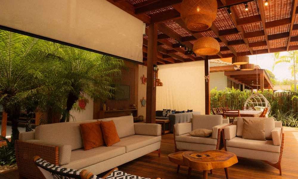 Un espace de vie extérieur avec canapés, fauteuils et lumières suspendues