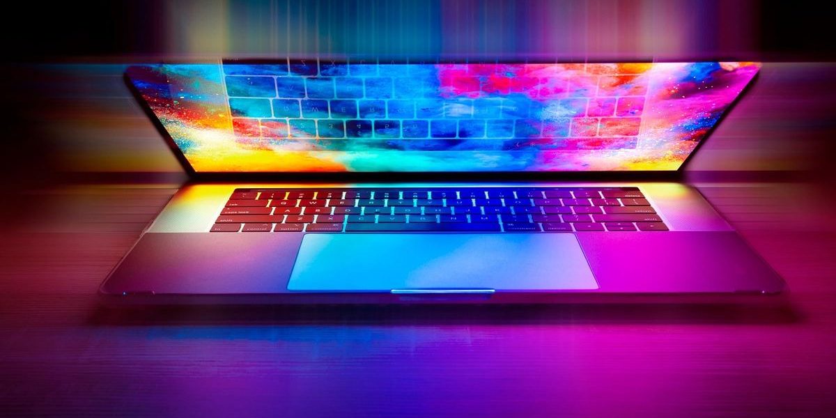 Laptop ouvert sur table, écran affichant un motif arc‑en‑ciel coloré