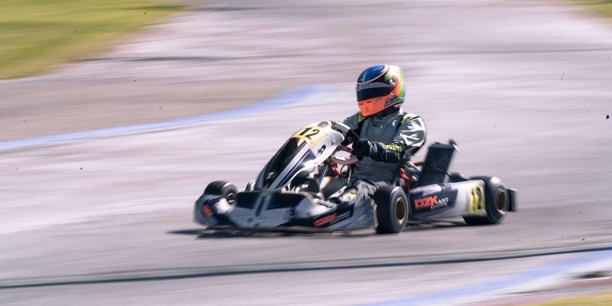 Un pilote en kart de course sur circuit, vitesse ressentie